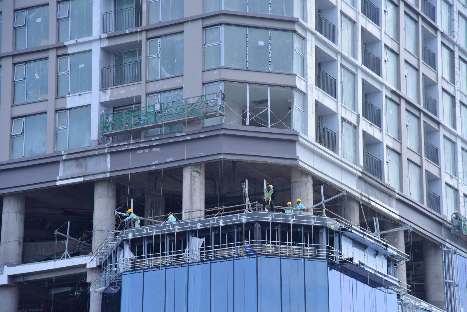 High-rise building construction with workers on site in urban setting